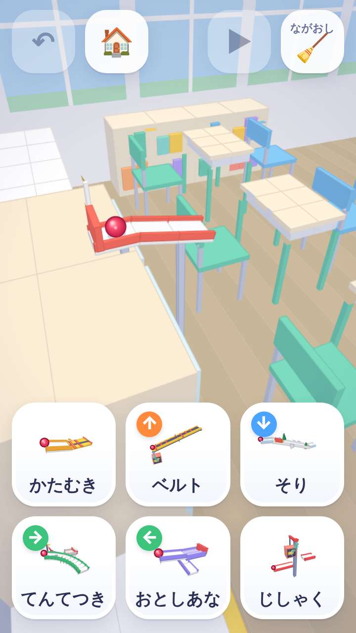 ころりこの画面写真 —— コースを作る画面。教室の机といすの上にレールとビー玉があり、下につなぐ部品のカードが並んでいる